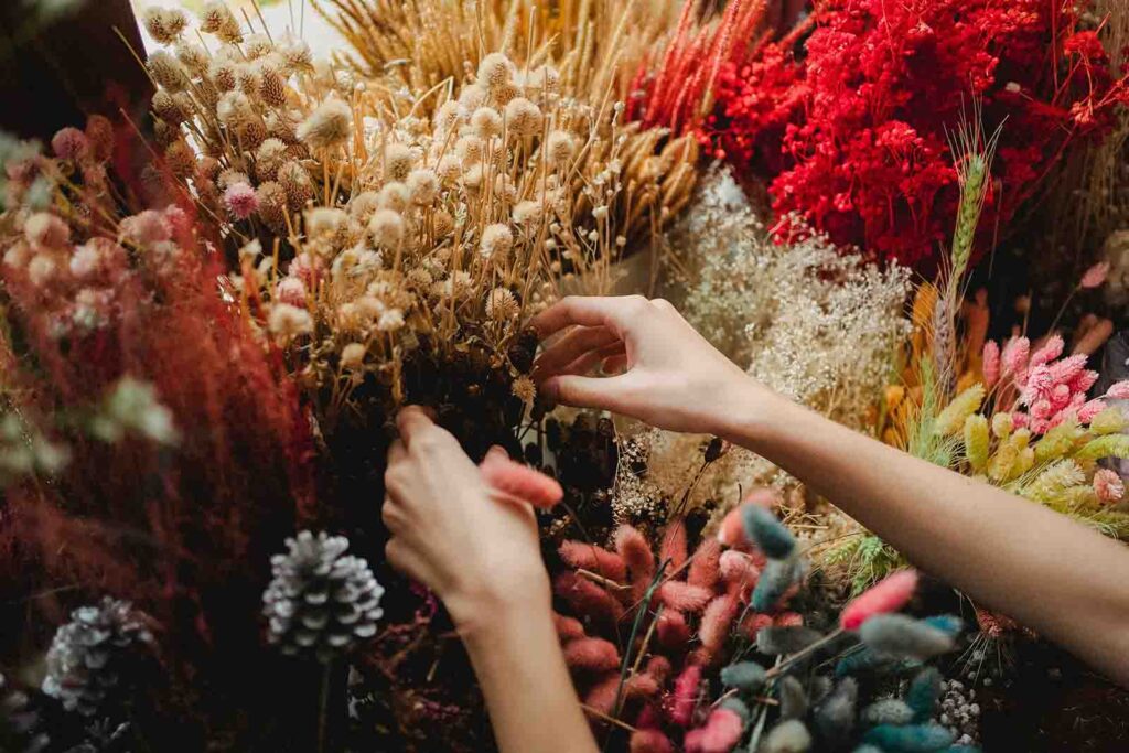 Hands selecting dried flowers at the European Holiday Market.